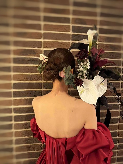 ウェディングブーケを持った赤いドレスの花嫁の後ろ姿